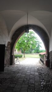 TOSZEK, zachodnia arkada wejścia (XIV w.) w budynku bramnym z widokiem na dziedziniec