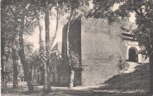 KOŹLE, Brama zamkowa na przedzamczu wbudowana w mur przedzamcza w XV wieku (z prawej strony), obok niej kaponiera z XVI wieku (po lewej stronie bramy) obecnie nieistniejąca – (widokówka z ok. 1920 roku, zb. P. Siemko)