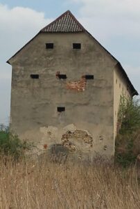 ZIEMIĘCICE, zachodnia elewacja spichlerza; spod odpadniętych tynków widoczny kamienny wątek dolnej kondygnacji i ceglany wątek górnej (fot. P. SIEMKO)