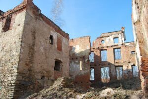 MIETKÓW, widok od płd.-wsch. na wieżę mieszkalną (z lewej) obudowaną XIX-wiecznym pałacem, obecnie w ruinie. . Na narożniku wieży zaznaczają się pozostałości tynkowej dekoracji w postaci pozostałości kwadr, 2012