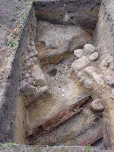 LIPINKI, widok na drewniany wieniec wzmacniający podnóże średniowiecznego kopca oraz narożniki fundamentów dwóch nowożytnych budynków, 2008 r. (fot. D. Nowakowski)