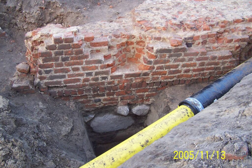 WROCŁAW, ZAMEK LEWOBRZEŻNY, relikty architektury muru obronnego (faza III), stojącego na reliktach wału piaszczysto-ziemnego (faza I). Widok od strony S, 2005 (fot. R. Mruczek z Archiwum AKME, Katalog Zamków i Dworów Obronnych Śląska [https://zamki.pwr.edu.pl/]. Licencja: CC BY-NC 4.0 [https://creativecommons.org/licenses/by-nc/4.0/])