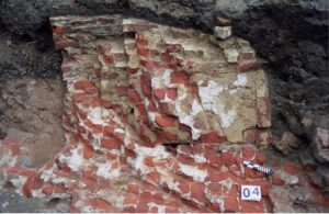 WROCŁAW, ZAMEK LEWOBRZEŻNY, relikty fundamentu filarowo-łękowego ściany E i prostopadłej do niej ściany działowej palatium – na styku z kaplicą (faza V, wraz z późniejszymi przebudowami z faz VIII-IX). Widok od S, 1999 (fot. R. Mruczek i M. Stefanowicz z Archiwum AKME, Katalog Zamków i Dworów Obronnych Śląska [https://zamki.pwr.edu.pl/]. Licencja: CC BY-NC 4.0 [https://creativecommons.org/licenses/by-nc/4.0/])