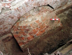 WROCŁAW, ZAMEK LEWOBRZEŻNY, relikt filara fundamentowego (faza VI), zachowany wraz z odcinkiem ściany W młodszego palatium (faza VI) pod E ścianą szczytową Gmachu Głównego Uniwersytetu Wrocławskiego oraz W ścianą nieistniejącego Gmachu Chemii. Widok od E, 2002 (fot. R. Mruczek z Archiwum AKME, Katalog Zamków i Dworów Obronnych Śląska [https://zamki.pwr.edu.pl/]. Licencja: CC BY-NC 4.0 [https://creativecommons.org/licenses/by-nc/4.0/])