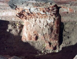 WROCŁAW, ZAMEK LEWOBRZEŻNY, relikt filara fundamentowego (faza VI), zachowany wraz z odcinkiem ściany W młodszego palatium (faza VI) pod E ścianą szczytową Gmachu Głównego Uniwersytetu Wrocławskiego oraz W ścianą nieistniejącego Gmachu Chemii. Widok od NE, 2002 (fot. R. Mruczek z Archiwum AKME, Katalog Zamków i Dworów Obronnych Śląska [https://zamki.pwr.edu.pl/]. Licencja: CC BY-NC 4.0 [https://creativecommons.org/licenses/by-nc/4.0/])