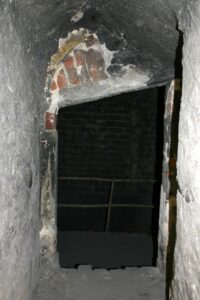 CHOCIANÓW, otwór przebity wtórnie w miejscu gotyckiego okna maswerkowego na poziomie poddasza – obecnie pełniący funkcję przejścia, 2005 (fot. A. Boguszewicz, Katalog Zamków i Dworów Obronnych Śląska [https://zamki.pwr.edu.pl/]. Licencja: CC BY-NC 4.0 [https://creativecommons.org/licenses/by-nc/4.0/] [https://creativecommons.org/licenses/by-nc/4.0/])