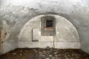 JĘDRZYCHÓW, To samo okienko w widoku z zewnątrz. Odsadzka ściany poniżej i wnęka przynależą do wieży z fazy 1. Piwnica powstała w wyniku jej rozbudowy w fazie 2 (fot. P. Błoniewski)